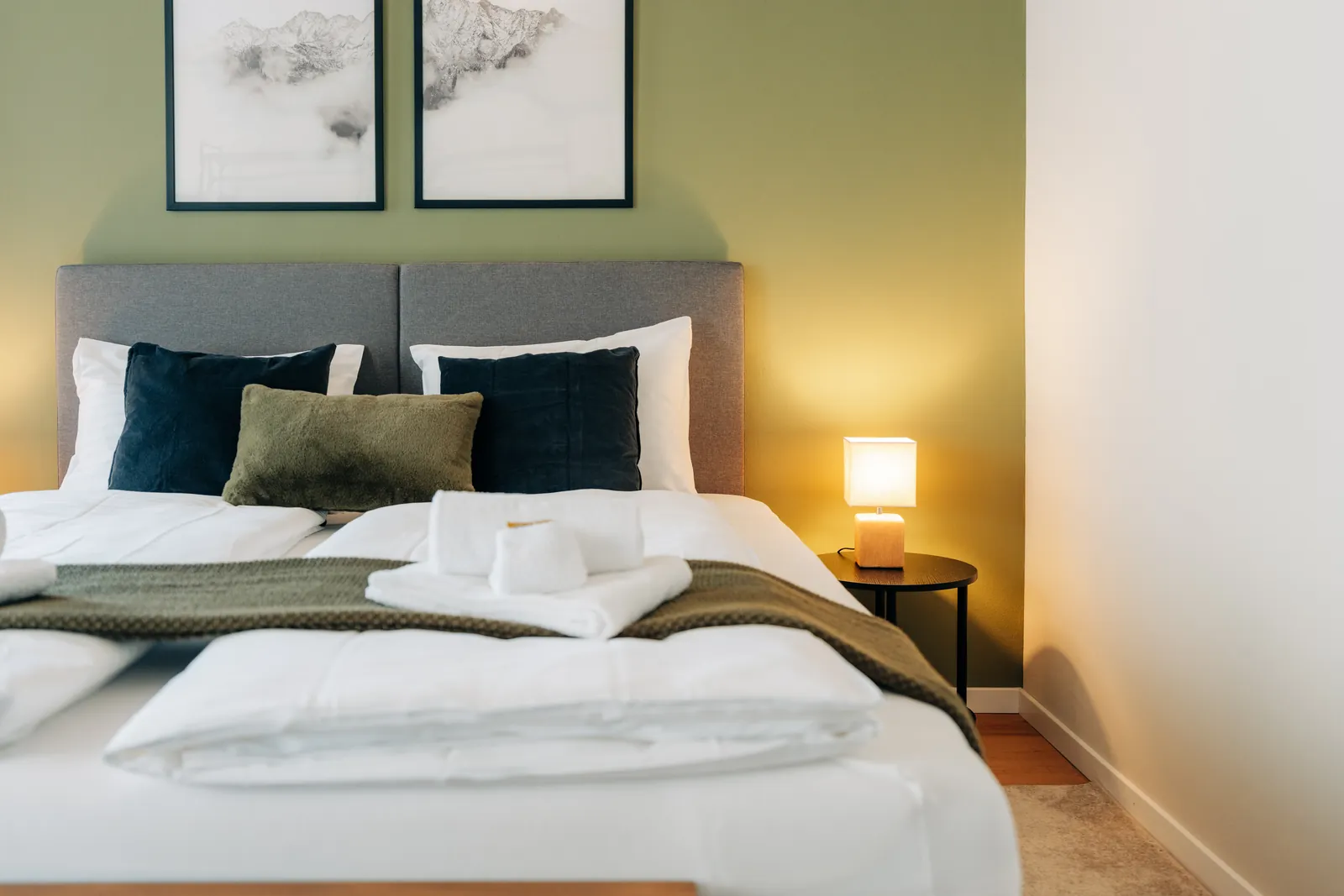 Schlafzimmer der Wohnung Central Suite One mit Doppelbett und grüner Wand
