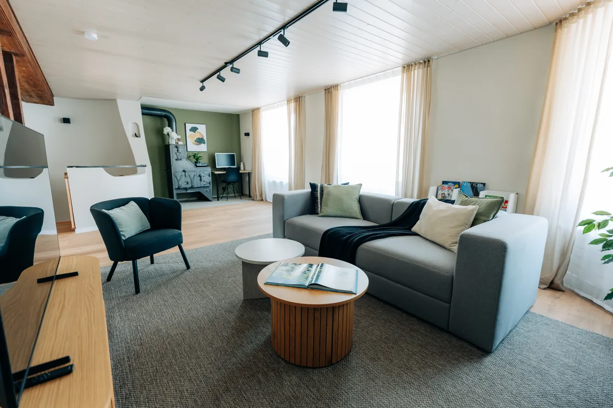Wohnzimmer der 120 m² Duplex-Wohnung Central Suite One mit Sofa und Holzbalken